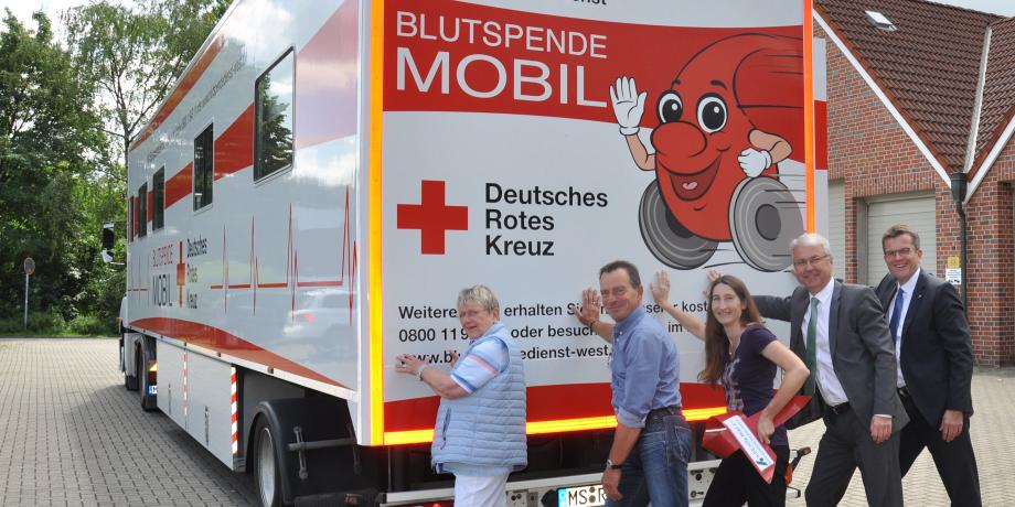 Personen schieben DRK LKW an