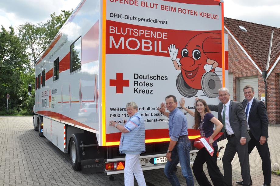Personen schieben DRK LKW an